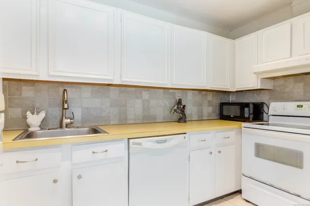 a kitchen with white cabinets and white appliances