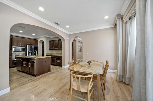 a kitchen with stainless steel appliances granite countertop a sink dining table and chairs