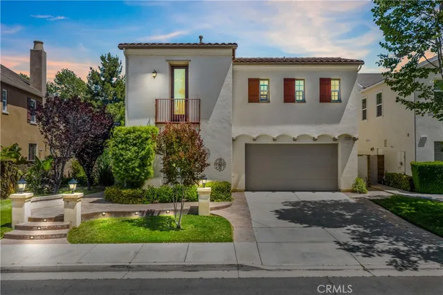 a front view of a house with garage and plants