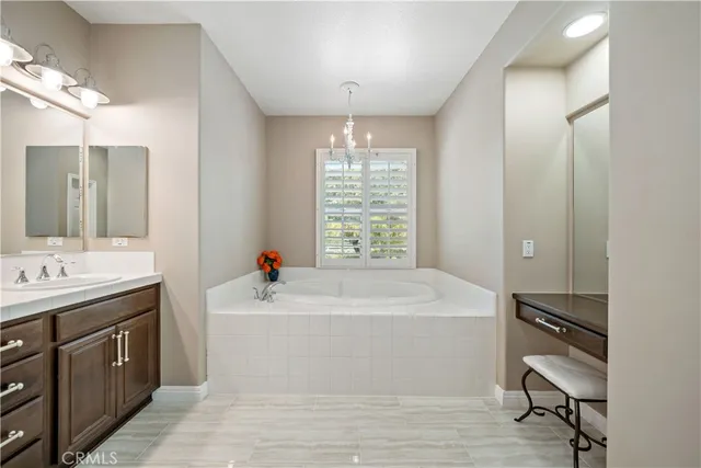 a bedroom with a bed a chandelier and dresser