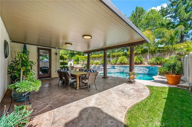 a view of a patio with a table chairs and a backyard