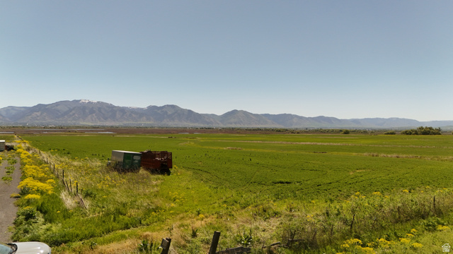 320 South 5400 West Logan, UT 84321 - Photo 11 of 42 Expansive green fields extending towards distant mountains under a clear sky
