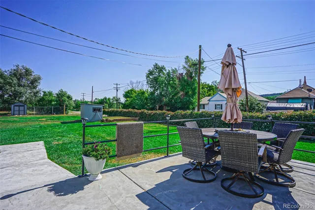a view of a patio with a table chairs and a yard