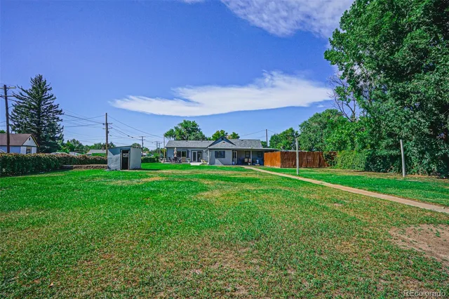 a view of a green field with house in the background