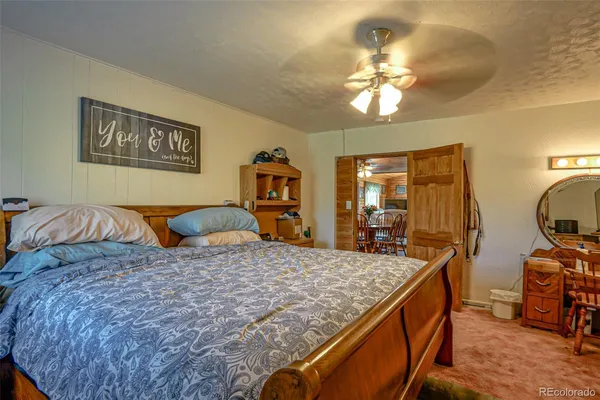 a large bedroom with a bed and wooden floor
