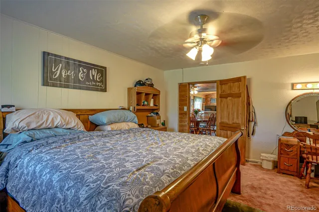 a large bedroom with a bed and wooden floor