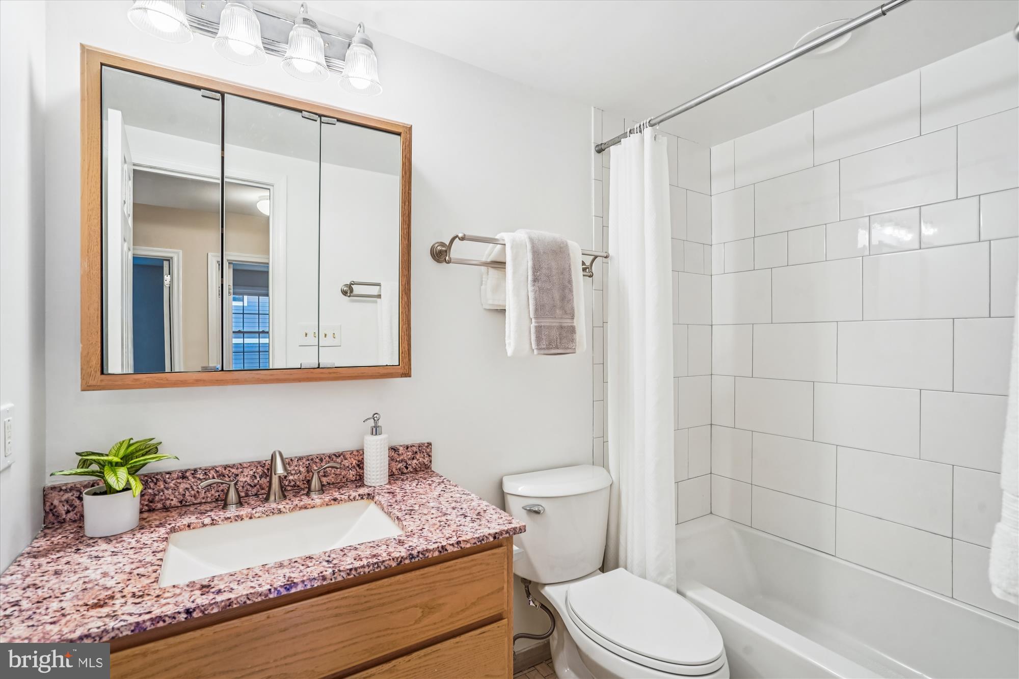 24 South Abingdon Street Arlington, VA 22204 - Photo 29 of 66 a bathroom with a granite countertop sink mirror vanity and toilet