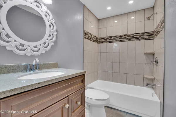 a bathroom with a granite countertop sink a toilet and bathtub