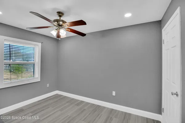 an empty room with a window and a fan