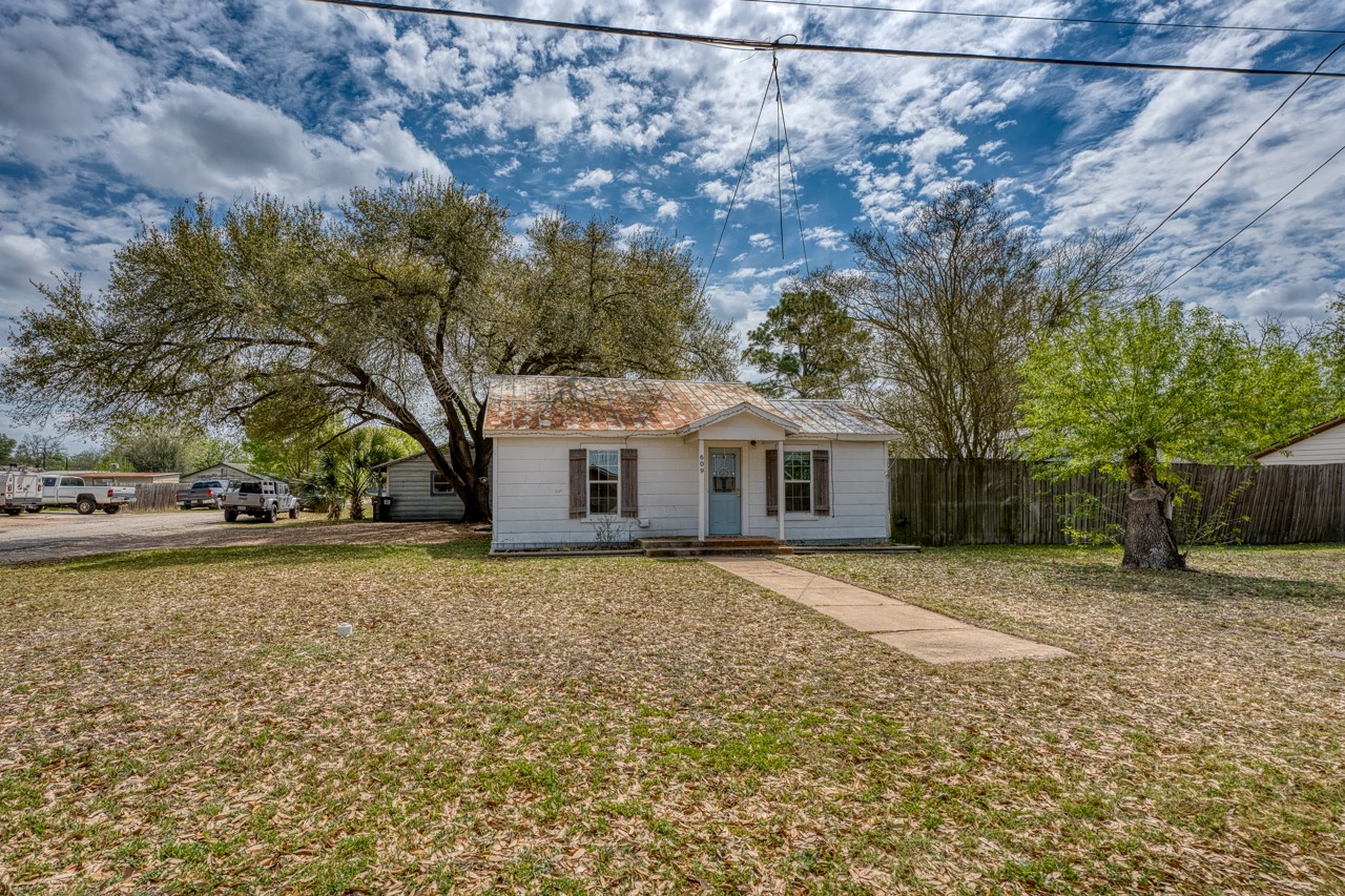 a front view of a house with a yard and trees