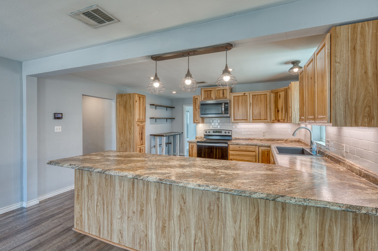 609 Dickson Street Lexington, TX 78947 - Photo 5 of 36 a kitchen with stainless steel appliances granite countertop a sink and a stove