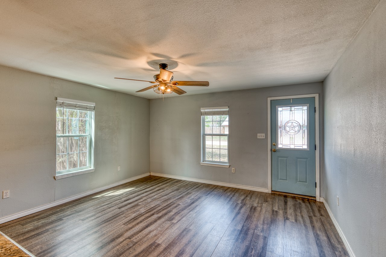 609 Dickson Street Lexington, TX 78947 - Photo 6 of 36 a view of an empty room with a window and wooden floor