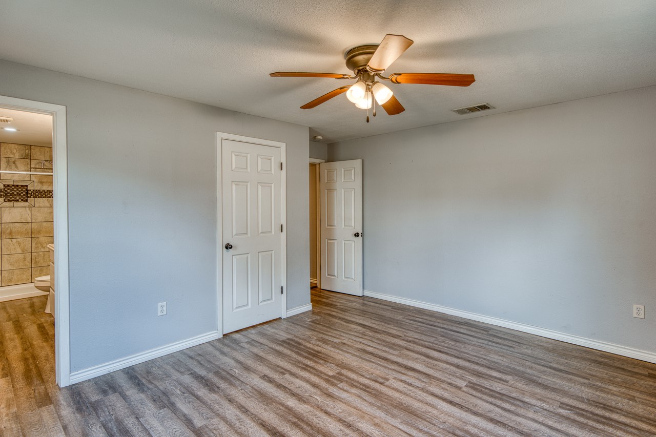 609 Dickson Street Lexington, TX 78947 - Photo 9 of 36 an empty room with wooden floor fan and windows