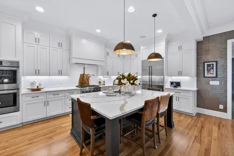 a kitchen with stainless steel appliances granite countertop a sink a stove and a wooden floors