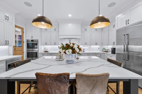 a kitchen with stainless steel appliances granite countertop a sink a stove and a wooden floors