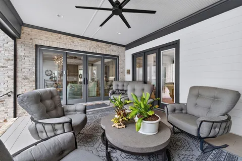 a living room with furniture a flat screen tv and a window