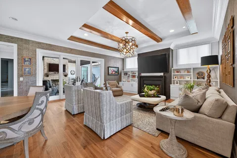 a kitchen with stainless steel appliances granite countertop a stove a refrigerator a oven a sink a dining table and chairs with wooden floor