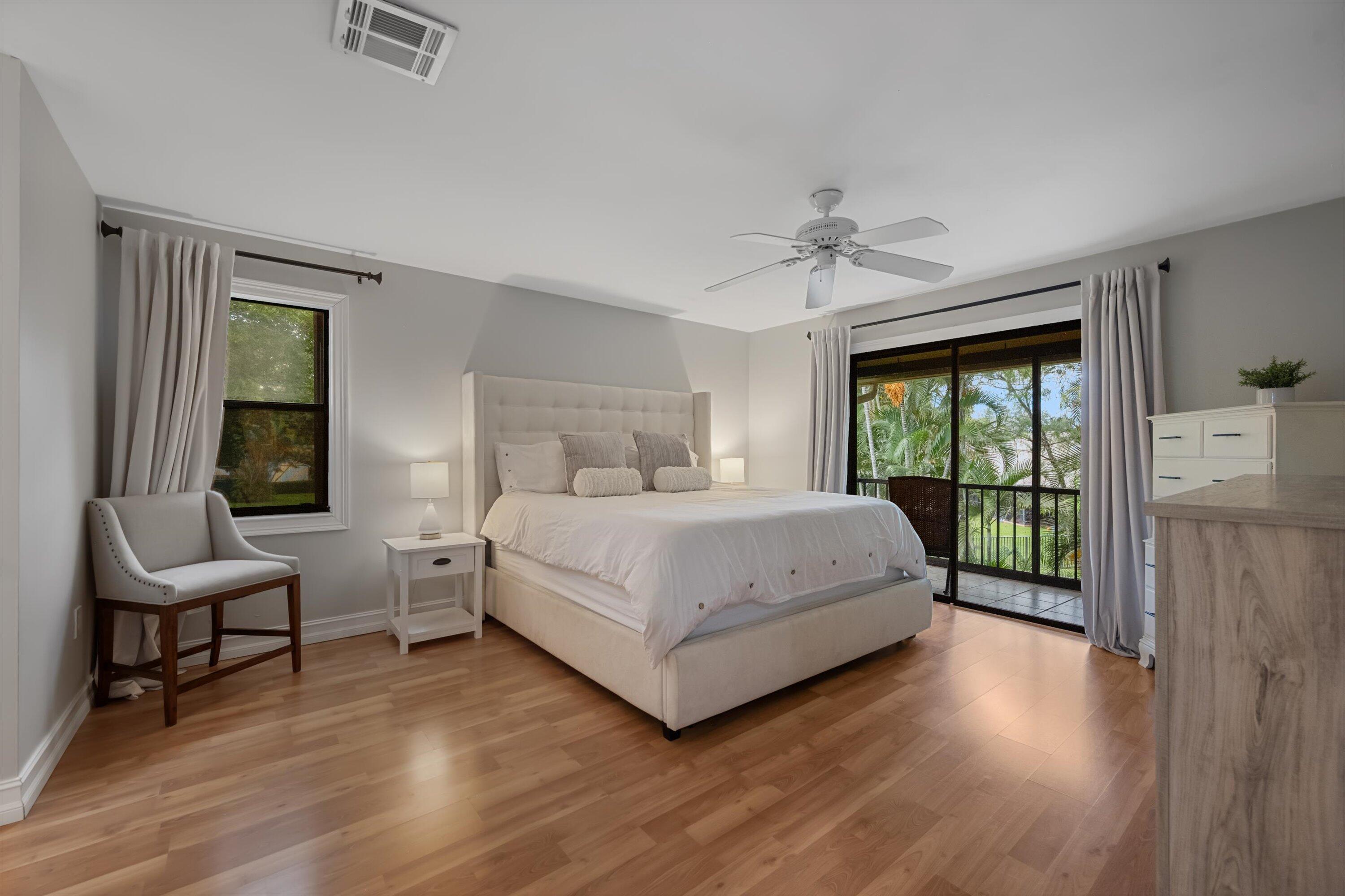 12970 Dartford Trail, Unit 4 Wellington, FL 33414 - Photo 14 of 23 a bedroom with a bed and a chandelier