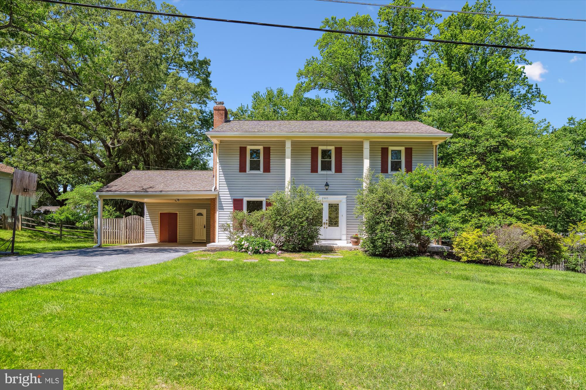 a front view of a house with a yard and trees