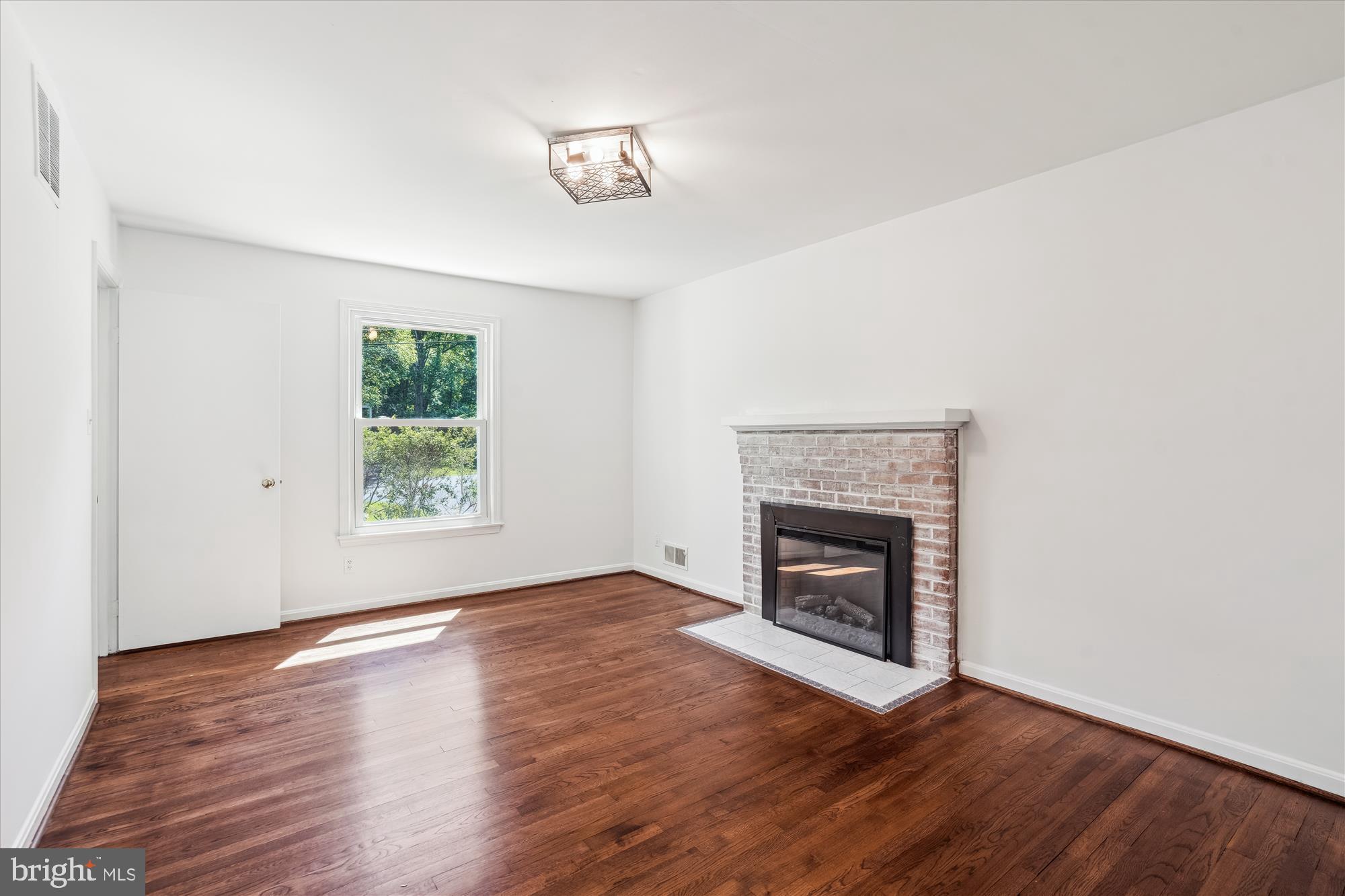 2445 Parallel Lane Silver Spring, MD 20904 - Photo 5 of 82 a view of an empty room with wooden floor and a window