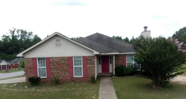 a view of a house with a yard and potted plants