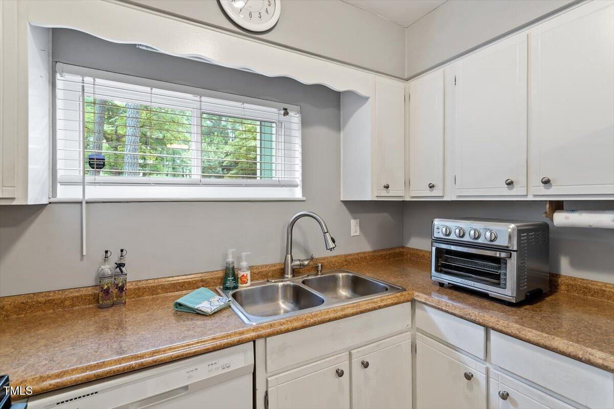 712 Godwin Court Raleigh, NC 27606 - Photo 10 of 27 a kitchen with stainless steel appliances granite countertop a sink a stove and cabinets
