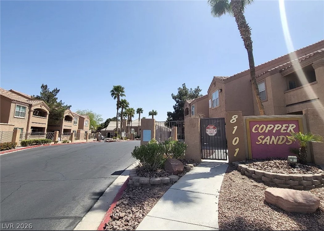 8101 West Flamingo Road, Unit 2131 Las Vegas, NV 89147 - Photo 12 of 13 Secure community entry with Mediterranean-inspired architecture and desert landscaping.