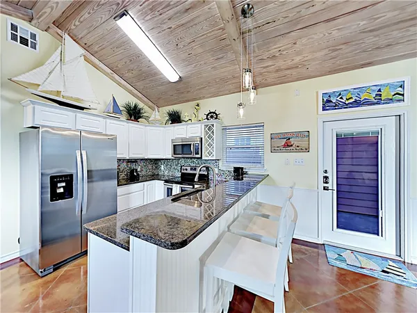 a kitchen with stainless steel appliances granite countertop a sink a stove and cabinets