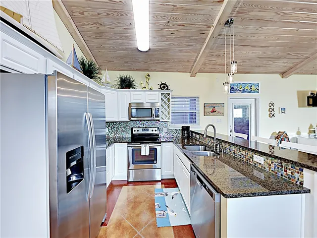 a kitchen with stainless steel appliances granite countertop a sink window and refrigerator
