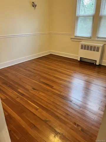 a view of a room with wooden floor and brick walls