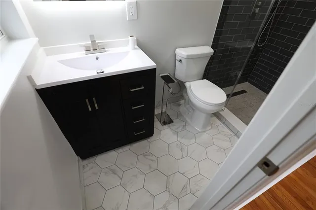 an empty room with wooden floor chandelier fan and windows