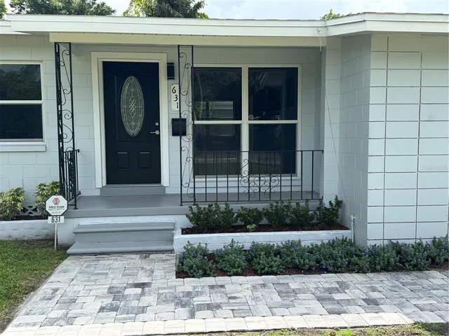 a front view of a house with a garden and yard