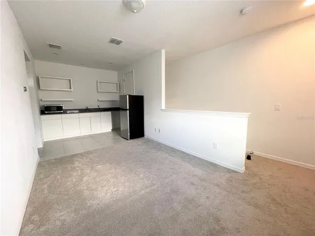 a view of a kitchen with a sink and a refrigerator