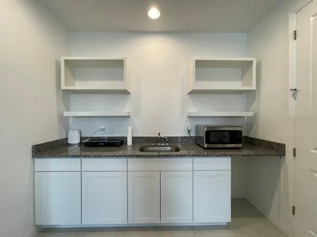 a kitchen with white cabinets and appliances