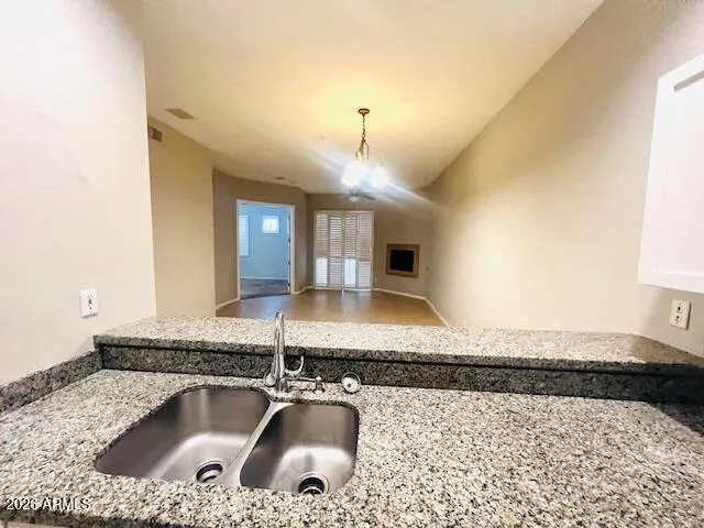 a kitchen with granite countertop a sink a stove and cabinets