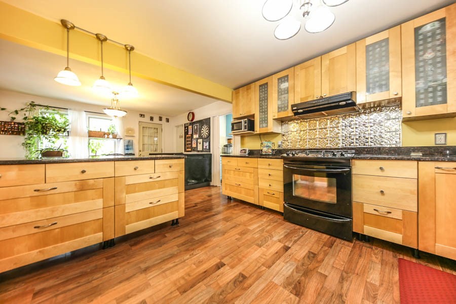 4 Riverview Place Lawrence, MA 01841 - Photo 12 of 21 a kitchen with stainless steel appliances kitchen island granite countertop a stove a sink and white cabinets with wooden floor