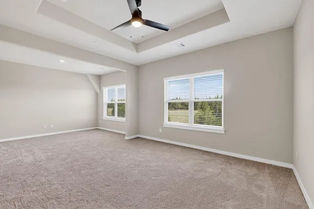 an empty room with a window and a ceiling fan