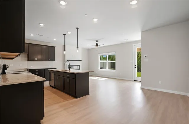 a large kitchen with stainless steel appliances kitchen island wooden cabinets and granite counter tops