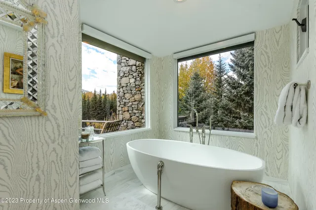 a bathroom with a sink a bathtub and next to a window