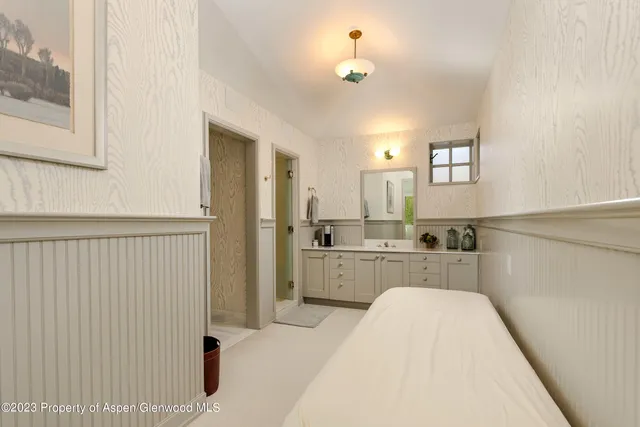 a large white kitchen with sink and refrigerator
