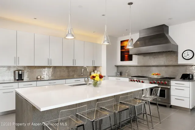 a kitchen with a sink a stove and chairs