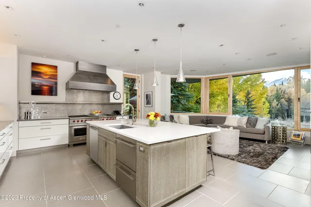 a kitchen with a stove sink and view living room