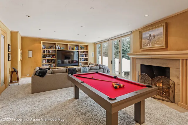 a room with pool table and windows