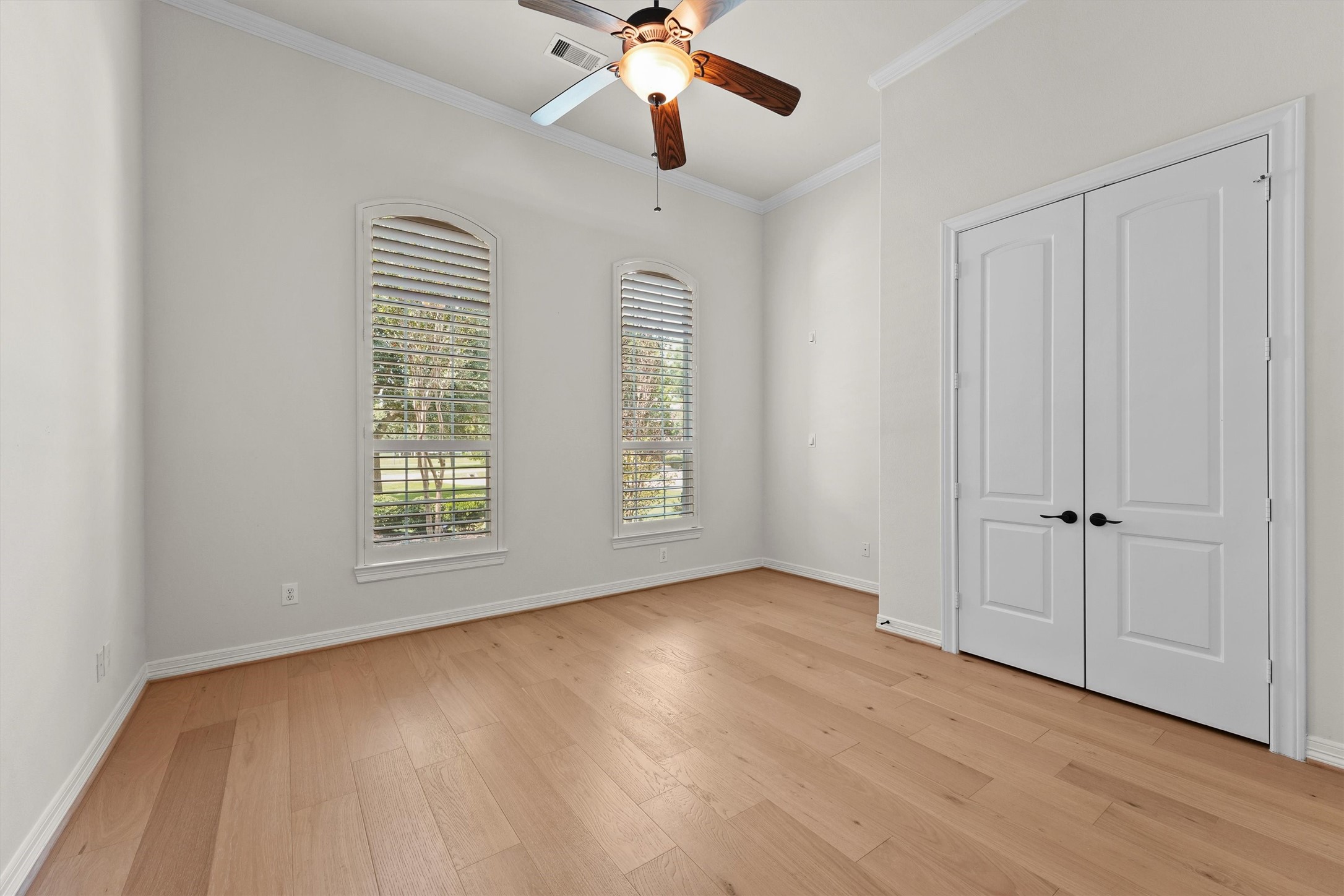 4102 Worthing Drive Fulshear, TX 77441 - Photo 16 of 30 an empty room with wooden floor chandelier fan and windows