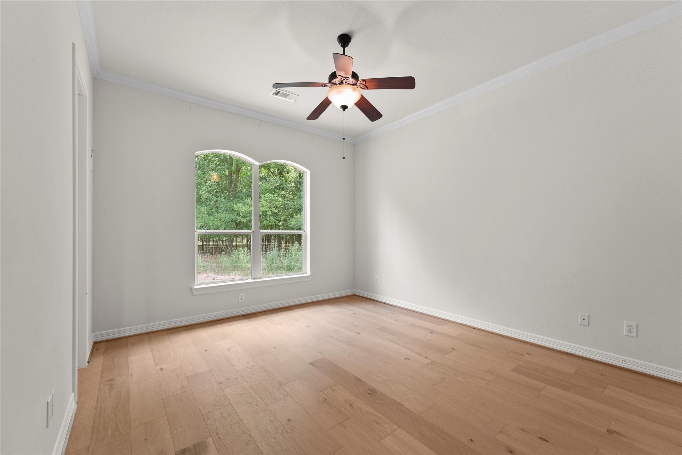 4102 Worthing Drive Fulshear, TX 77441 - Photo 18 of 30 an empty room with a window a chandelier fan and wooden floor