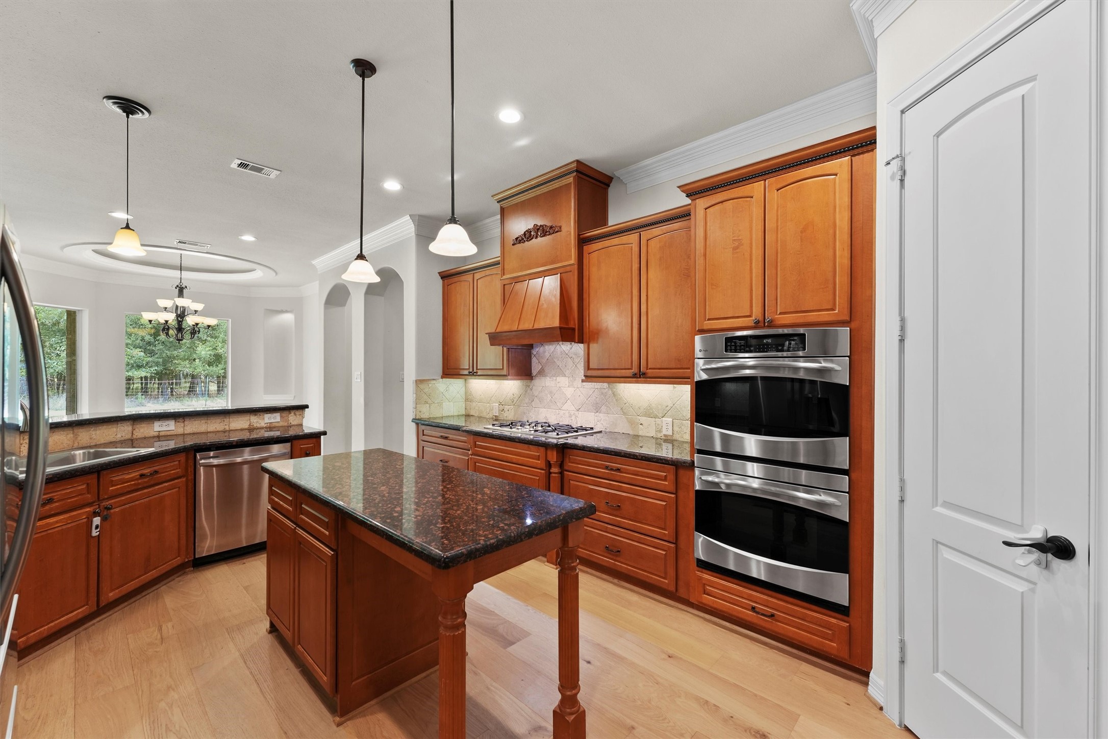 4102 Worthing Drive Fulshear, TX 77441 - Photo 10 of 30 a kitchen with stainless steel appliances granite countertop a stove a sink and a refrigerator with wooden floor