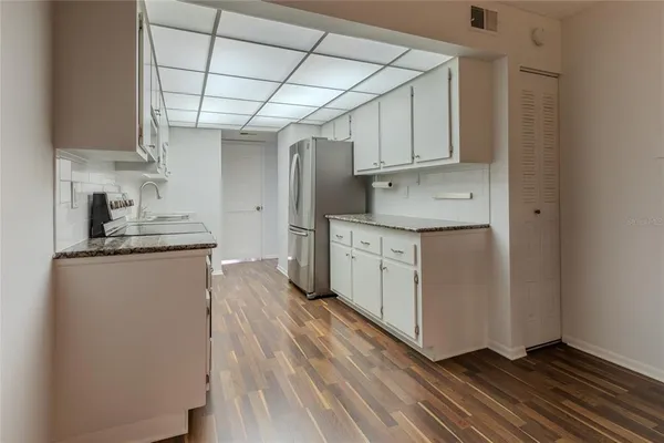 a kitchen with cabinets and wooden floor