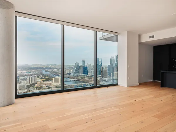 an empty room with windows and city view