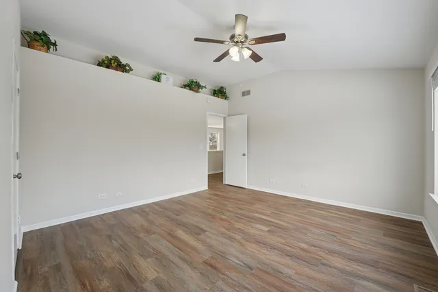 a view of a big room with wooden floor and a ceiling fan