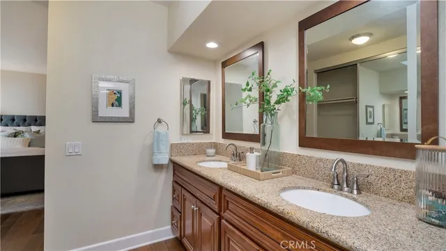 a bathroom with a granite countertop sink mirror and toilet